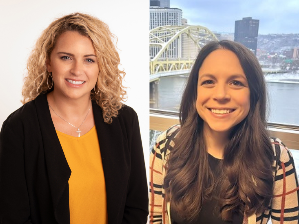 Two women smiling: the left has curly blonde hair, wearing a yellow top and black blazer; the right has long dark hair, wearing a plaid jacket.