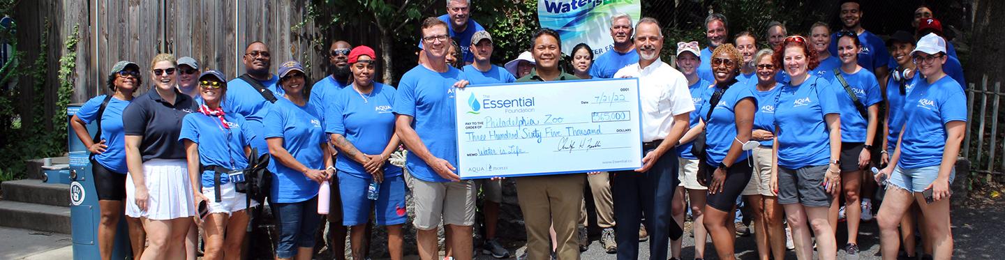 Aqua employee presenting check to volunteer group